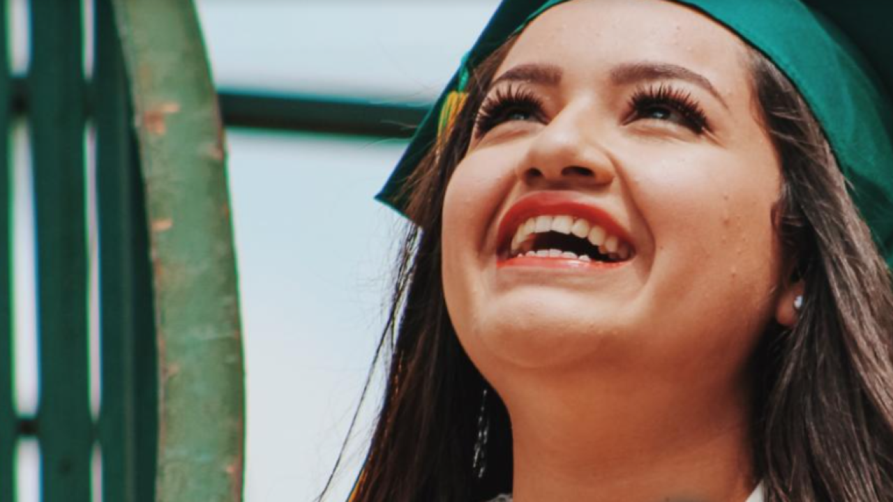 Smiling student with a green mortar board