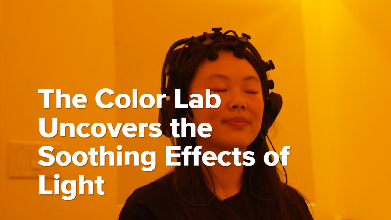 A student participates in a color experiment with amber light in the background.