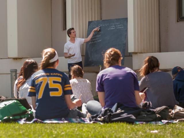 Graduate student teaching outside with chalkboard
