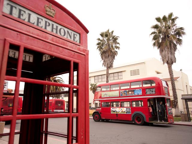 Red telephone booth with red double decker bus in background