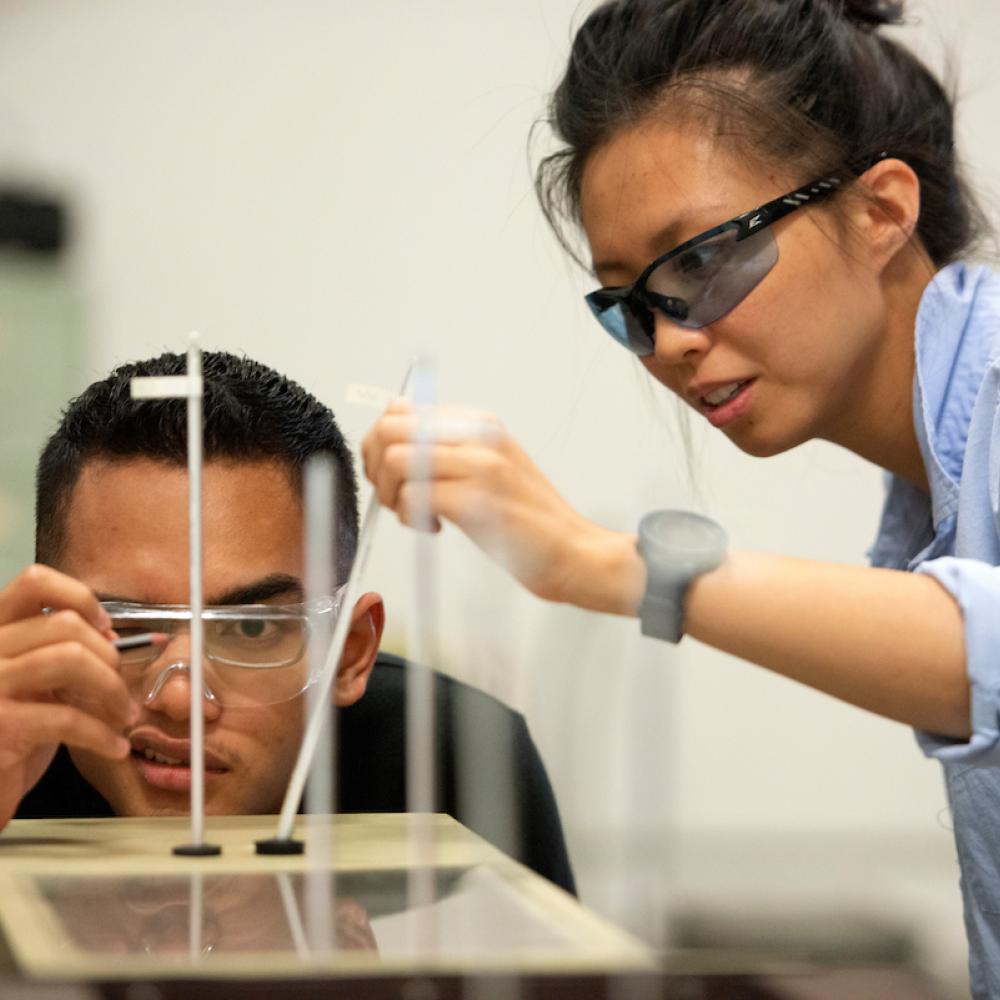 Students studying wind tunnel instruments in a lab