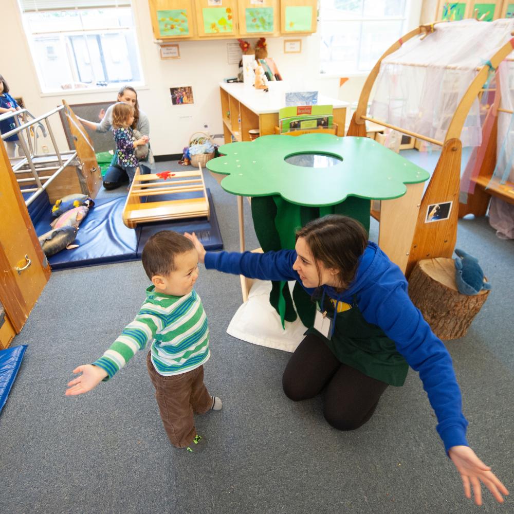 A student plays with a child at the campus childcare center
