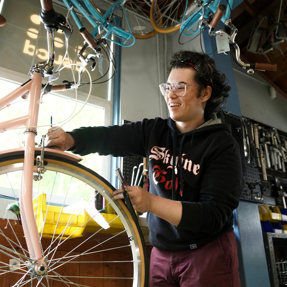 A student employee works on a bike in the Bike Barn