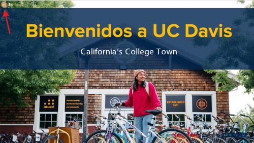 Student standing with a bicycle in front of a bike rack and campus building