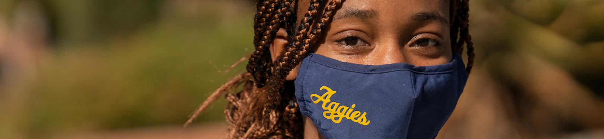 Student wearing Aggies-branded facemask