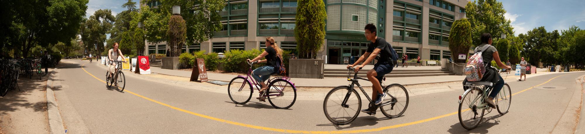 Bicycles ride past the library