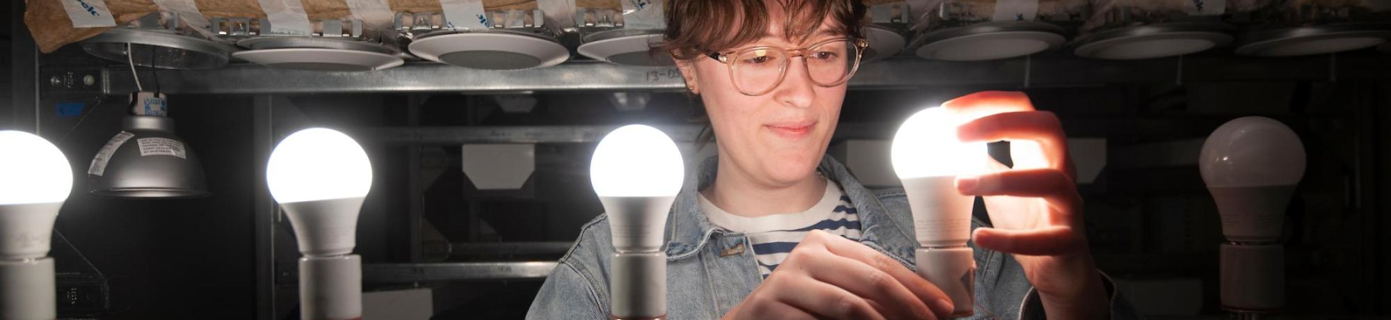 Student installing LED bulbs