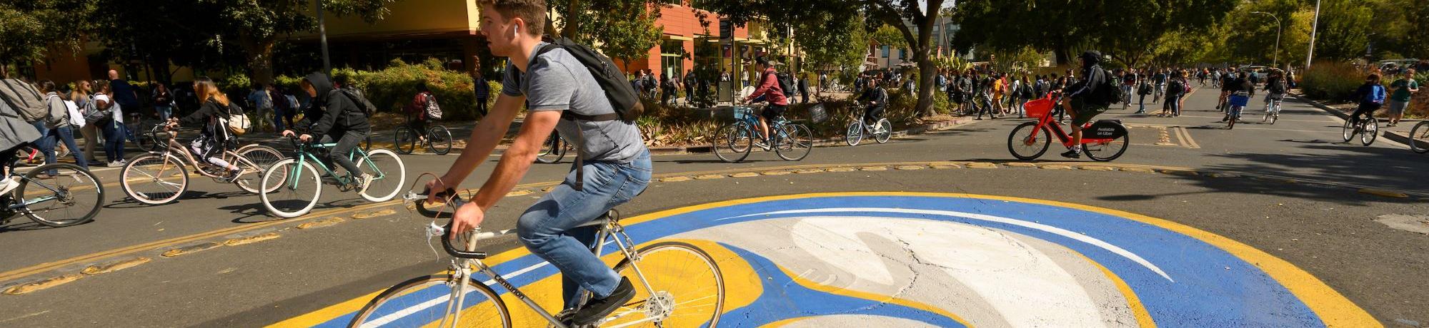 A student rides a bicycle through central campus bike circle