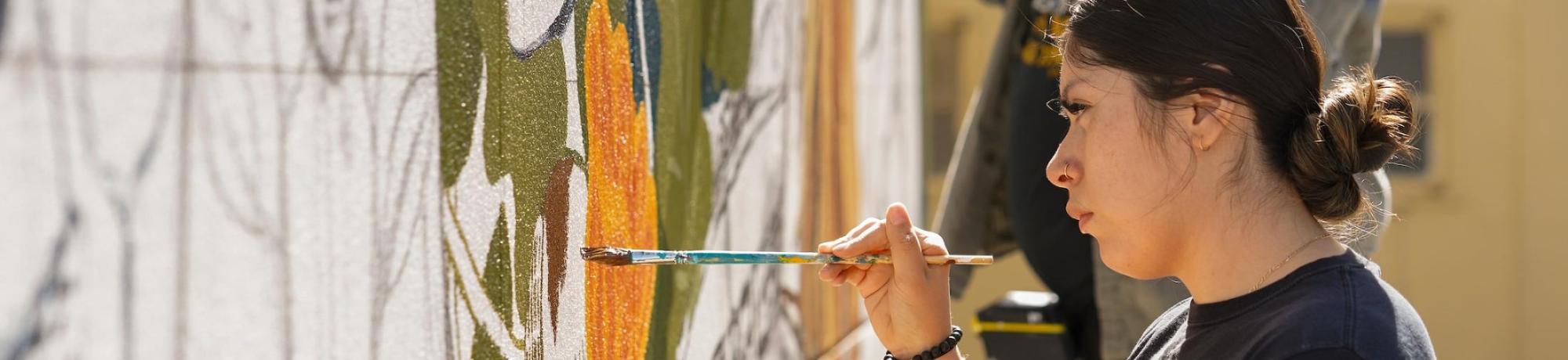 Students painting an outside mural