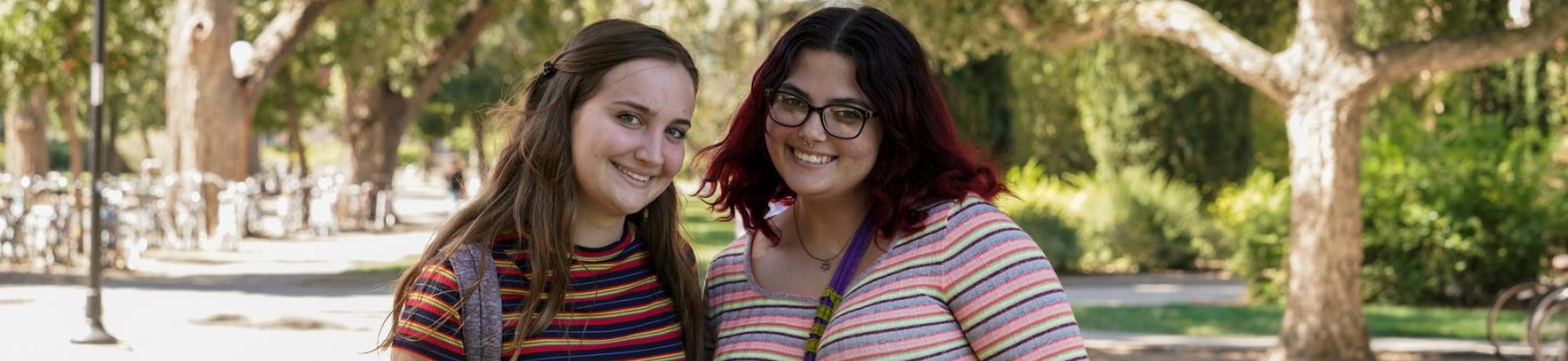 Two students in striped shirts smiling