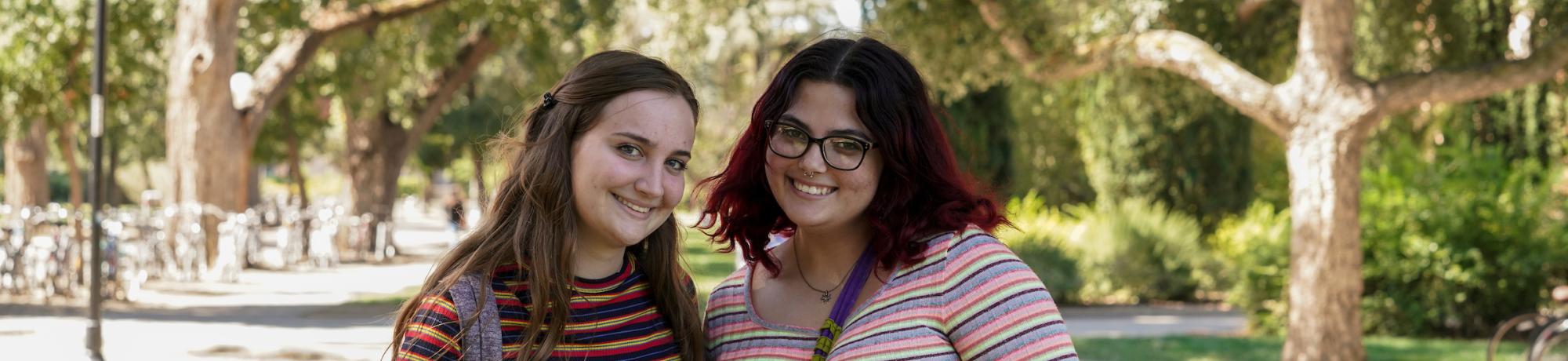 Two students in striped shirts smiling
