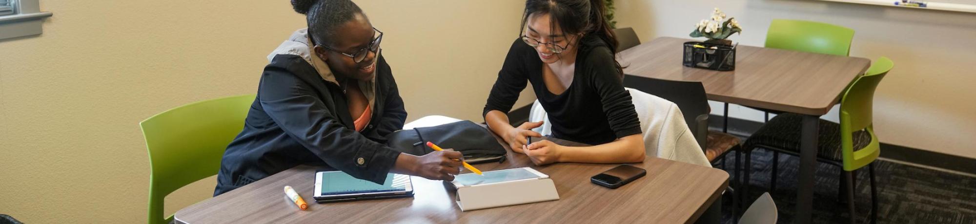 Two students working together at a table