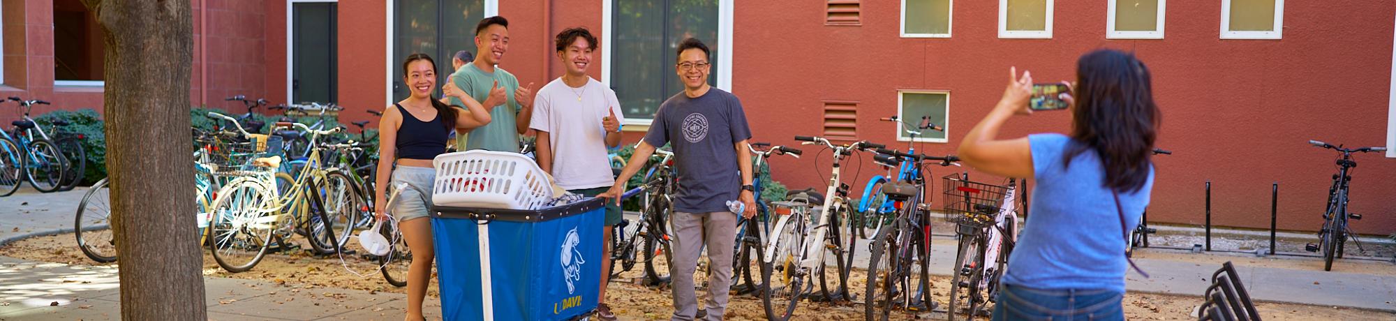 A family poses for a picture in front of the dorms on move-in day.
