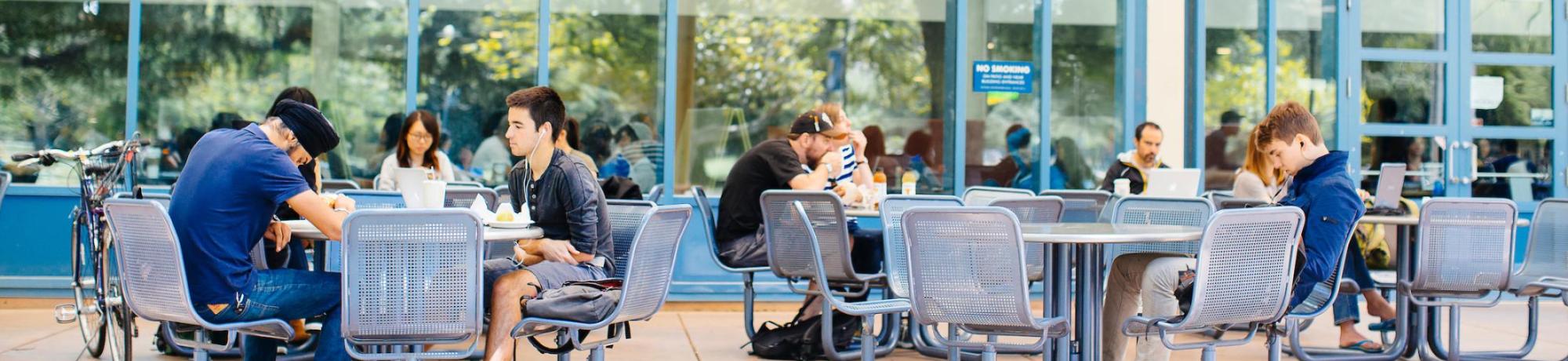 Students at tables outside MU