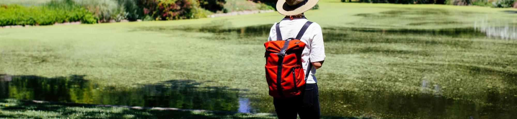 Student with red backpack walking in quad